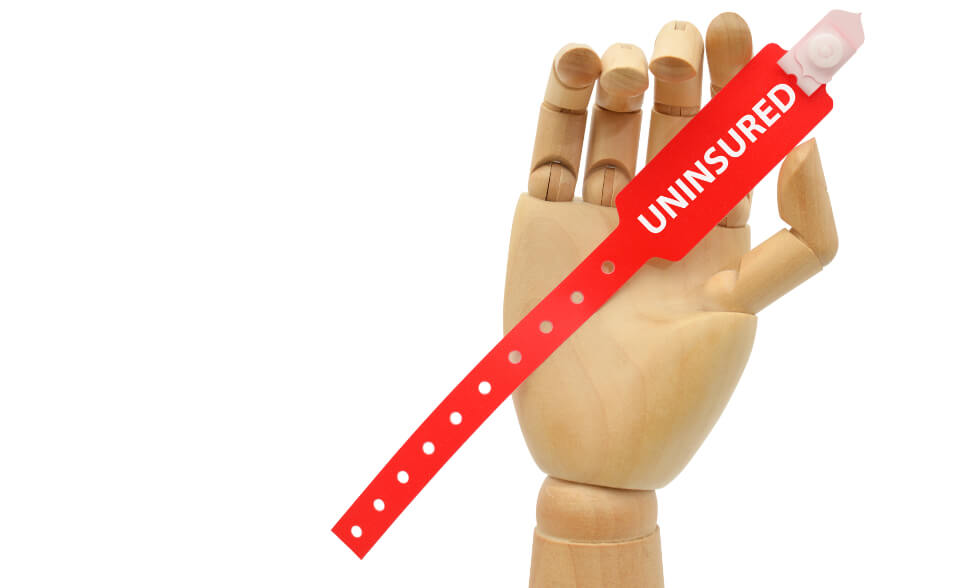 puppet hand holding a tag labeled uninsured